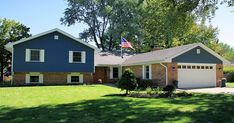 a blue house with an american flag in the front yard