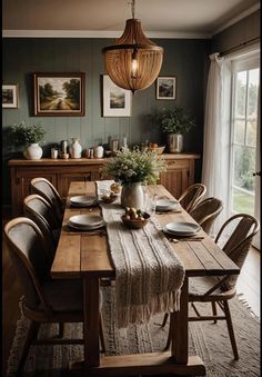 a dining room table with plates and place settings on it, in front of a large window