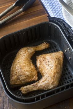 two pieces of cooked chicken in a black pan