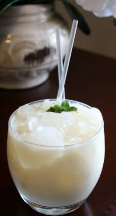 a glass filled with milk and topped with a green leaf