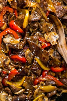 beef stir fry with peppers and onions in a brown bowl