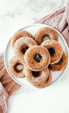 a white plate topped with donuts covered in powdered sugar