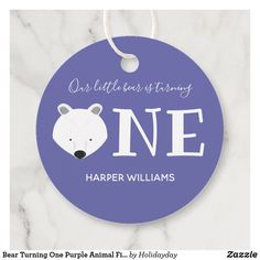 a blue ornament with a white polar bear and the words one little bear is trying to be one