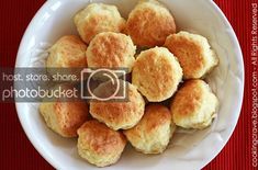 a white bowl filled with biscuits on top of a red table