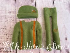 the doll is wearing a green sweater and pants with an orange stripe down the side