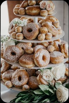 three tiered trays filled with donuts and flowers