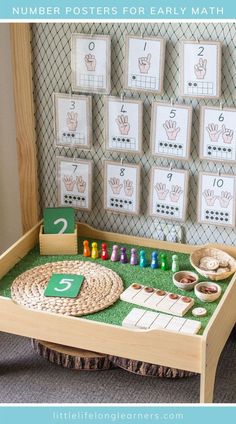 a child's wooden table with numbers and counting mats on the wall behind it