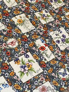 an old quilt with flowers and butterflies on it's edges is laying on the floor