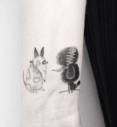 a woman's arm with a small tattoo of a dog and a cat on it