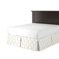 a bed with a white bedspread and brown headboard on top of it