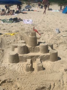 a sand castle on the beach with people in the background