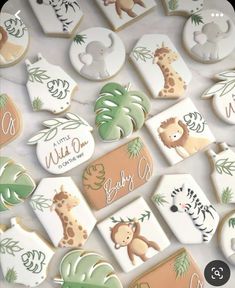 baby shower cookies decorated with giraffes, zebras, and palm leaves