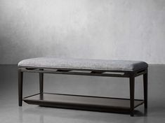 the bench is made from wood and has a gray upholstered cushion on it