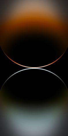 an orange and black circular object on a dark surface with light reflecting off the top