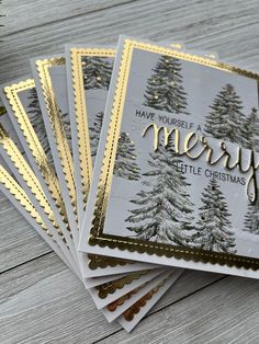 five christmas cards with pine trees on them, and the words have yourself merry written in gold foil