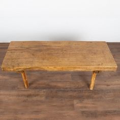 a wooden bench sitting on top of a hard wood floor