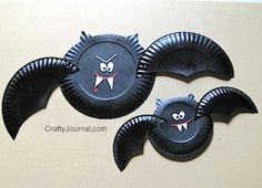 three black bats with eyes and fangs on them are sitting next to each other in front of a wall