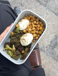 a person holding a container with food in it