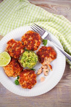 a white plate topped with crab cakes and guacamole