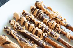 chocolate and peanut butter pretzels on a white plate with drizzles