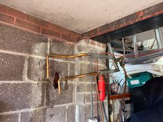 the inside of a garage with pipes and tools hanging on the wall next to it