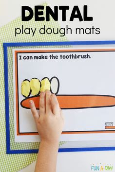 a child's hand is touching the toothbrush on a dental play dough mat