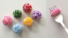 there are four different colored balls next to a fork