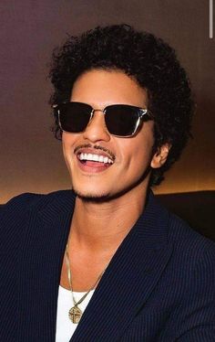 a close up of a person wearing sunglasses with a smile on his face and hair