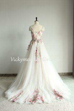 a white wedding dress with pink flowers on it