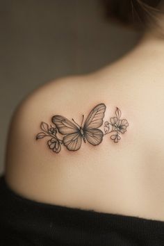 a woman with a butterfly tattoo on her upper back shoulder and behind her left shoulder