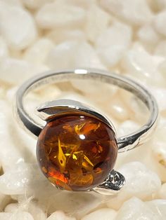 "* Materials: Baltic Amber, 925 Sterling Silver. * Stone color: Honey. * Stone size: 0.4\" x 0.4\"(10 mm x 10 mm). * Weight: 2.6 gram. * Available in sizes 6-8.5. * Perfect gift for her. * Matching earrings for a complete set is available. * This ring is for adults only. Honey Natural Baltic Amber Ring. Did you know that Amber was one of the first materials ever used for accessorizing? Ornaments made out of amber were found on prehistoric people dating all the way back to the Stone Age, which was over 10,000 years ago! Throughout centuries it has been known for its healing properties and widely used all over the world. Today, the lore of amber still continues to inspire people. Baltic amber is known to be the most rare and precious of Ambers. When it comes to natural healing, harmony and w Amber Stone Aesthetic, Silver And Amber Ring, Silver Amber Jewelry, Nature-inspired Amber Jewelry With Natural Stones, Amber Crystal Ring With Sterling Silver, Prehistoric People, Unique Amber Sterling Silver Jewelry, Amber Rings, Amber Fossils