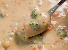 a spoon full of soup with broccoli and cheese