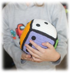 a child holding a crocheted ball in their hands