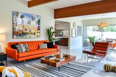 a living room filled with furniture and a painting on the wall