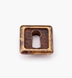 an old, rusty metal object with a keyhole in the center on a white background