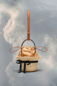 Luxury Straw Bucket Bag With Woven Leather, Luxury Straw Bucket Bag With Bamboo Handle, Luxury Woven Leather Straw Bucket Bag, Luxury Natural Straw Bucket Bag, Luxury Straw Bucket Bag With Top Handle, Luxury Top Handle Straw Bucket Bag, Luxury Summer Basket Bucket Bag, Luxury Basket-shaped Bucket Bag For Summer, Luxury Leather Summer Bucket Bag