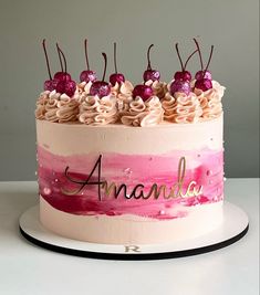 there is a cake with pink and white frosting on the top that says amanda