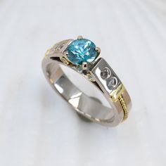 This breathtaking Blue Zircon & Diamond Classical Ring presents the perfect blend of classic and modern elements. Crafted from 18K palladium white gold, the ring sparkles with a dazzling 1.05ct blue zircon and is subtly accented with 18KY gold granulation and diamonds for a truly eye-catching display. Truly exquisite, this timeless piece is sure to turn heads. 18K palladium white gold ring with 18K yellow gold granulation is set with a gorgeous 1.05ct blue zircon and .20cttw VS/G-H diamonds. Siz Modern Elements, Sparkling Rings, Blue Zircon, White Gold Ring, White Gold Rings, Timeless Pieces, Gold Ring, Diamonds, White Gold