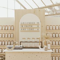 a white table topped with pictures and vases filled with flowers next to a sign that reads grounded in faith and love