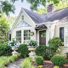 a white house surrounded by lush green plants