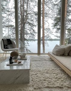 a living room filled with lots of furniture next to a large window covered in snow