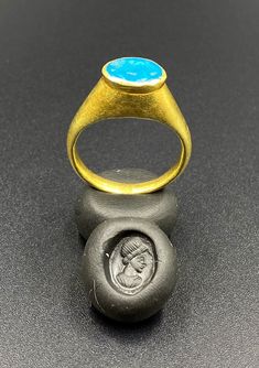 The Beautiful Gold Ring Probably From Ancient Greek's Time With Turquoise Color Blue Glass Stamp. A Beautiful Head Of A Man Figure Engraved On This Blue Glass. Seals Was Mostly Carved In Carnelian Or Garnet In Ancient Times But On Glass Very Rare. We Can Provide Gold Certificate On Customers Request.18 Karat Gold. We Provide Fast And Free Shipping World Wide. Luxury Blue Turquoise Ring For Formal Occasions, Blue Cabochon Signet Ring For Anniversary, Blue Oval Hallmarked Signet Ring, Luxury Blue Oval Cabochon Turquoise Ring, Blue Hallmarked Signet Ring, Luxury Blue Ring With Bezel Setting, Blue Cabochon Signet Ring, Oval Blue Intaglio Ring, Handmade Classic Blue Signet Ring