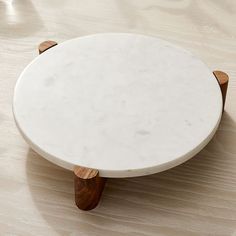 a white marble table with wooden legs