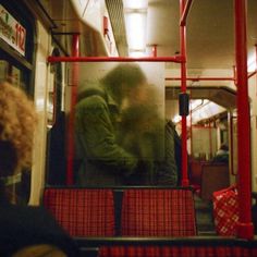 two people sitting on a bus with their backs to each other