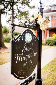 the sign for steel magnanalia house is decorated with bells