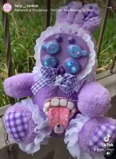 a purple and white teddy bear with its mouth open