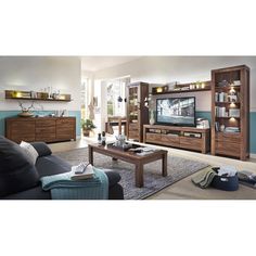 a living room filled with furniture and a flat screen tv on top of a wooden entertainment center