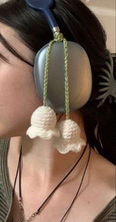 a woman is wearing ear buds made out of yarn