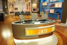 an empty television studio with chairs and desks