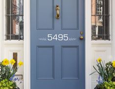 a blue door with the number 5495 on it and some flowers in front